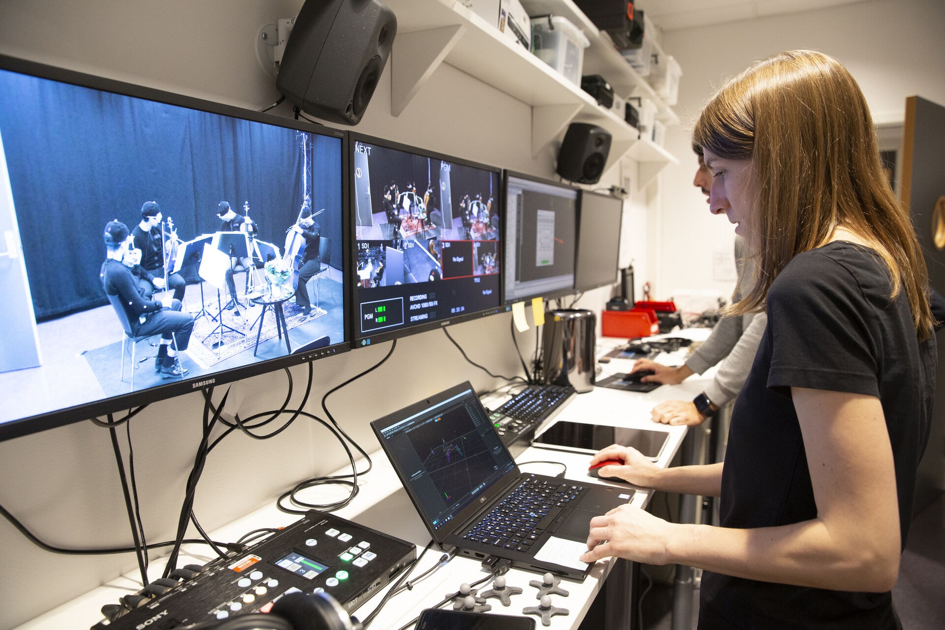 The control room: screens showing the lab, a mixer and a researcher at work