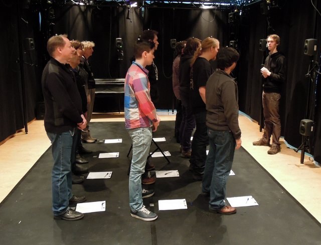 Participants standing still in rows on the lab floor, each on a marked spot