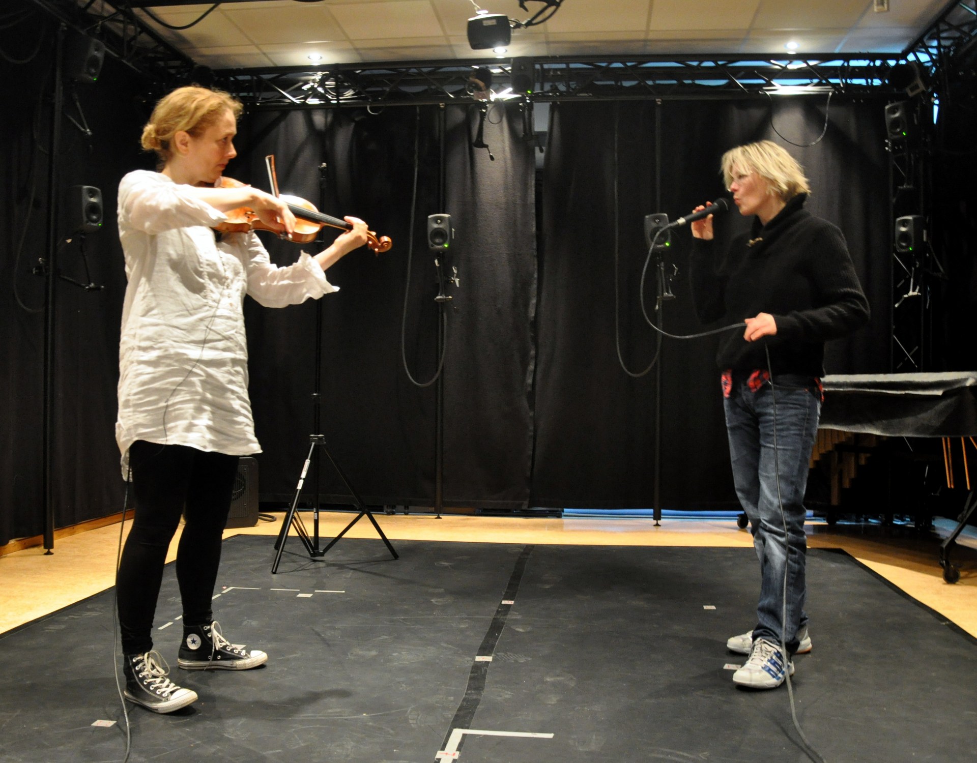 A violinist and a singer performing together in the lab